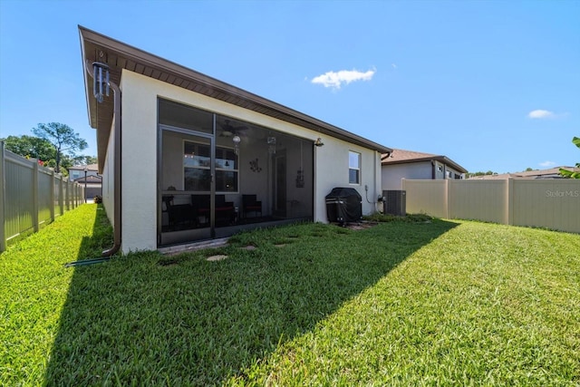 rear view of property with a lawn and central AC unit