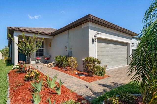 20591 Monza Loop, Land O Lakes, FL 34638 - view of home's exterior with stucco siding, driveway, and an attached garage
