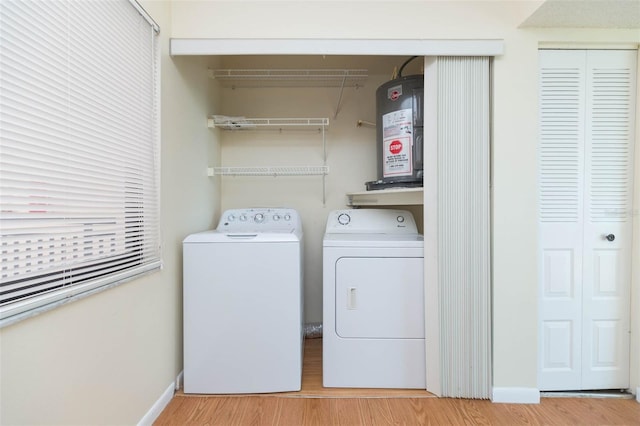 laundry area featuring light hardwood / wood-style floors, washing machine and dryer, and water heater