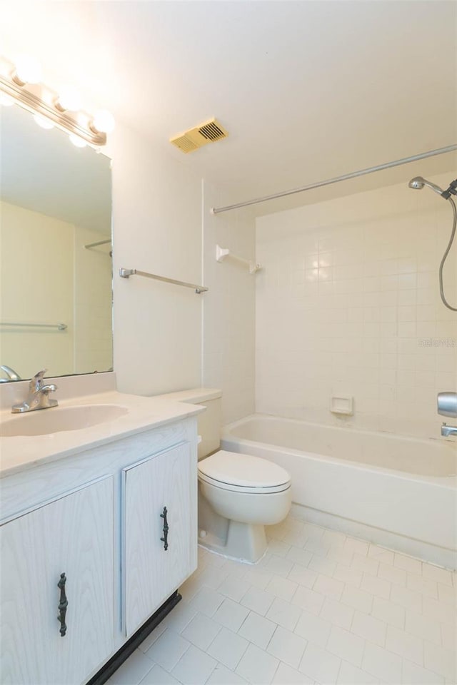 full bathroom with tile floors, tiled shower / bath, oversized vanity, and toilet