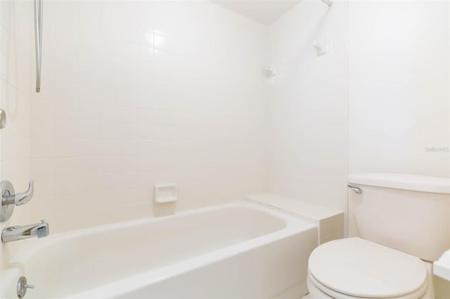 bathroom featuring tiled shower / bath and toilet