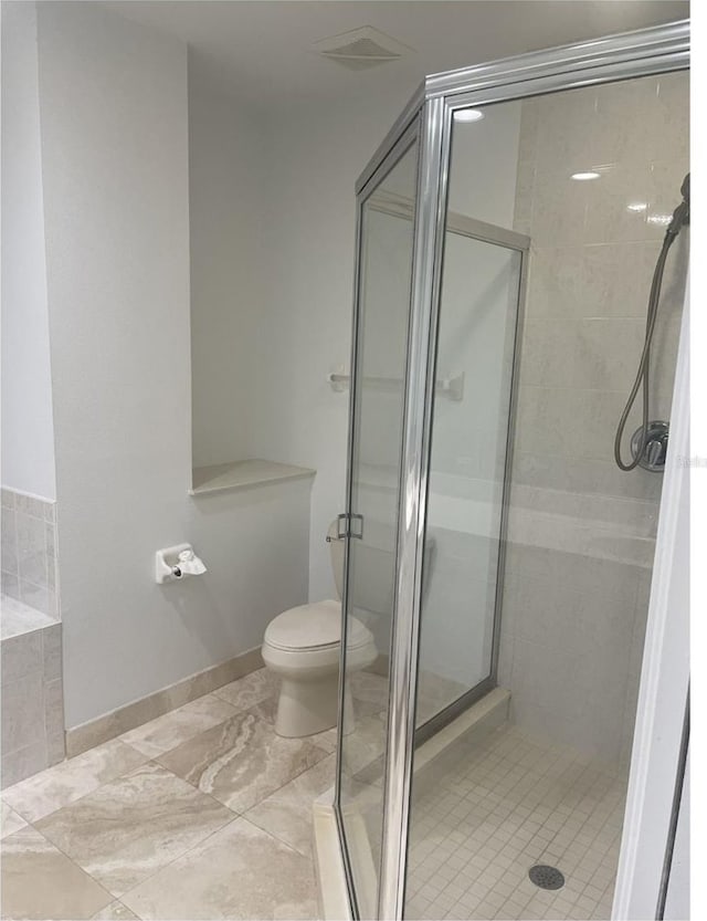 full bath with a relaxing tiled tub, toilet, baseboards, a shower stall, and visible vents