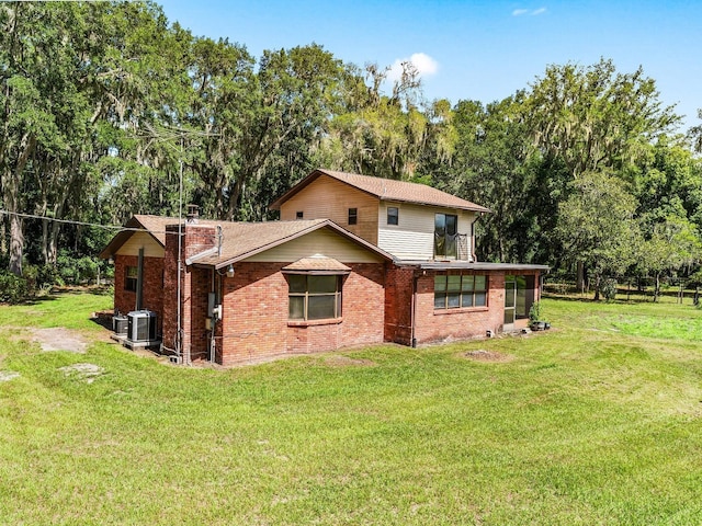 view of front of house with a front lawn and central AC unit