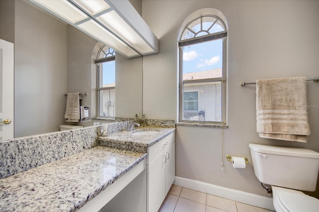 bathroom with tile patterned floors, plenty of natural light, toilet, and vanity