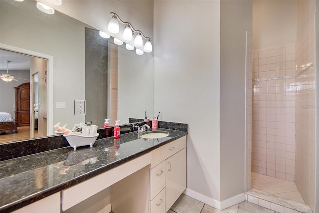 bathroom featuring a tile shower, tile patterned floors, and vanity