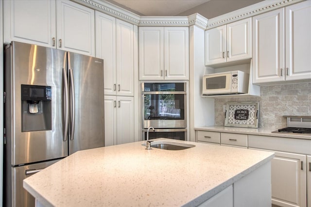 kitchen with white cabinetry, sink, tasteful backsplash, light stone counters, and appliances with stainless steel finishes