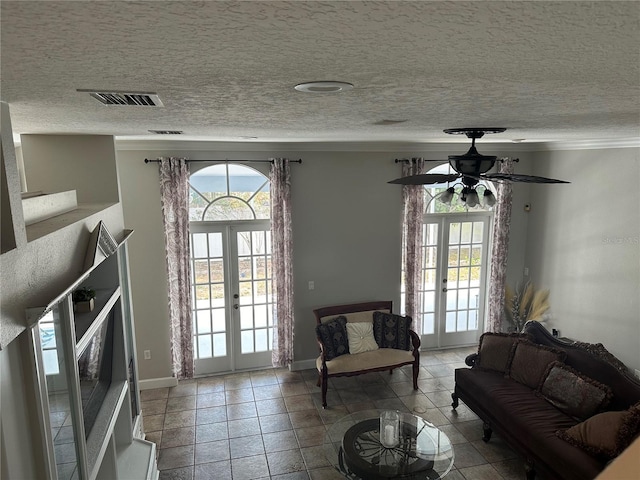 living room with ceiling fan, light tile patterned floors, a textured ceiling, and french doors