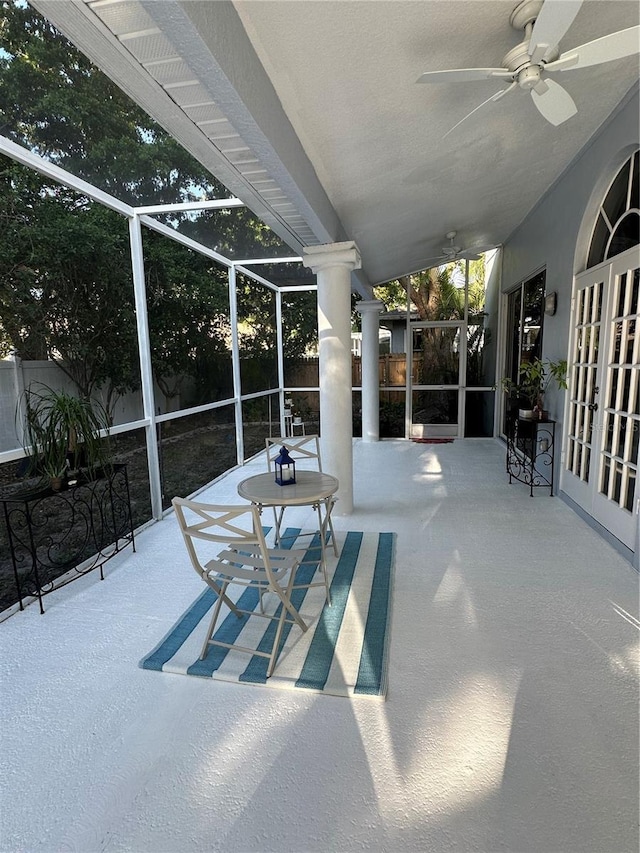 view of patio with ceiling fan and a lanai