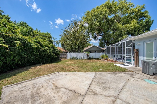 view of yard featuring central air condition unit, glass enclosure, a swimming pool, and a patio