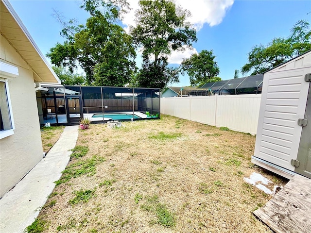 view of yard with glass enclosure and a fenced in pool