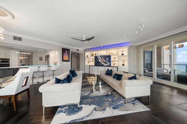 living room with a textured ceiling, dark parquet floors, ceiling fan, and crown molding