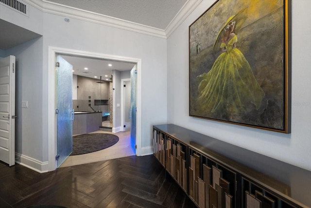 hall with a textured ceiling, dark parquet flooring, and crown molding