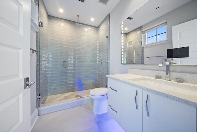 bathroom featuring tile patterned floors, a shower with door, vanity, and toilet