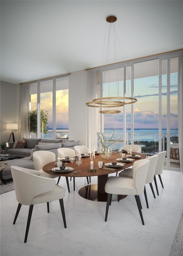 dining space with a water view and a notable chandelier