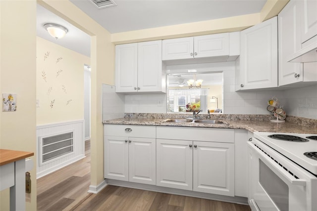 kitchen featuring sink, white cabinets, tasteful backsplash, and hardwood / wood-style flooring