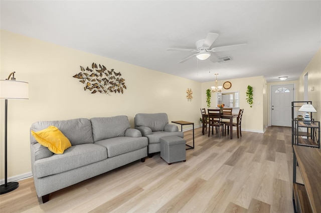 living room with hardwood / wood-style floors and ceiling fan with notable chandelier