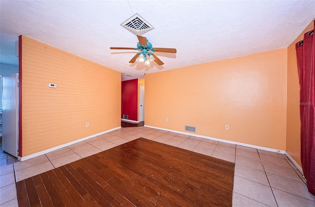 spare room with a textured ceiling, ceiling fan, and hardwood / wood-style floors