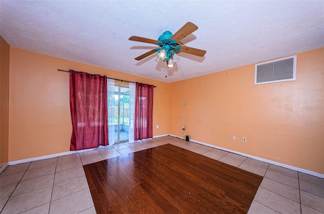 spare room with hardwood / wood-style floors, ceiling fan, and a textured ceiling