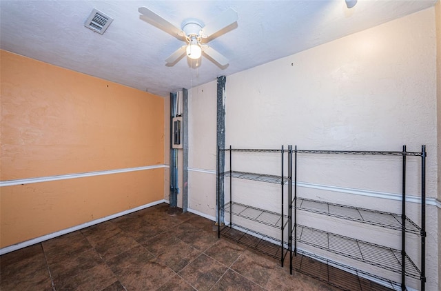 interior space with ceiling fan and dark tile floors