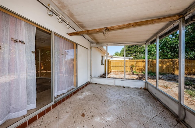 unfurnished sunroom with beamed ceiling