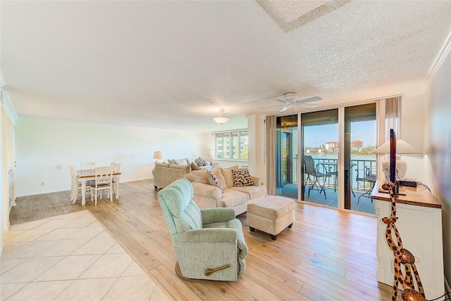 living room featuring floor to ceiling windows, ceiling fan, ornamental molding, a textured ceiling, and light hardwood / wood-style floors