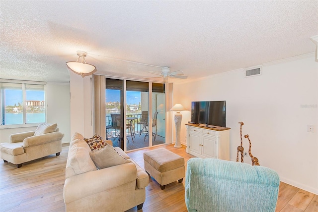 living room featuring a water view, crown molding, ceiling fan, and light hardwood / wood-style floors