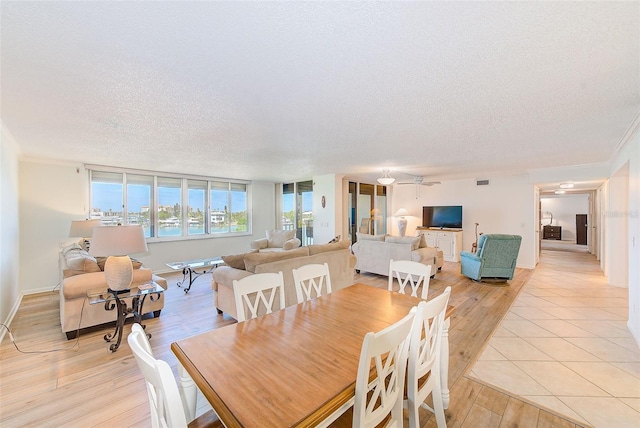 dining area with a textured ceiling and light wood-type flooring