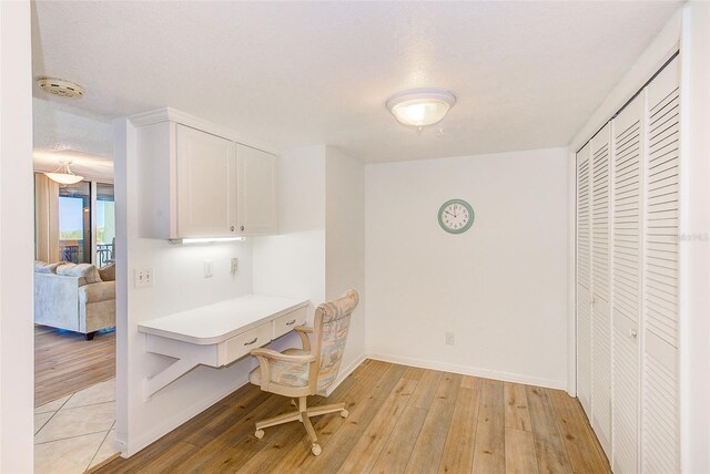 office space with a textured ceiling and light hardwood / wood-style flooring