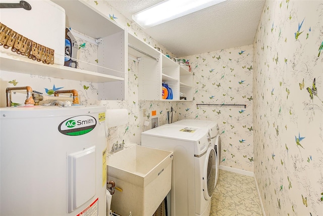 washroom with washer and clothes dryer, water heater, sink, and a textured ceiling