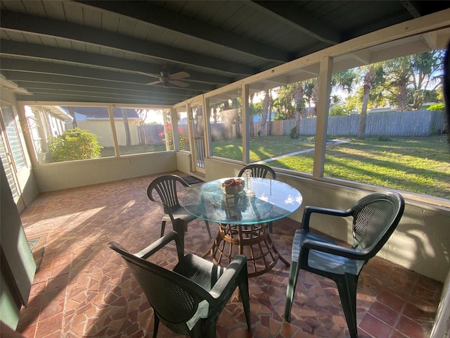 sunroom featuring ceiling fan and beam ceiling