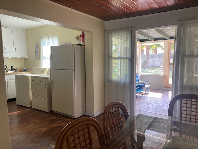 kitchen with white refrigerator, sink, independent washer and dryer, white cabinetry, and wood ceiling