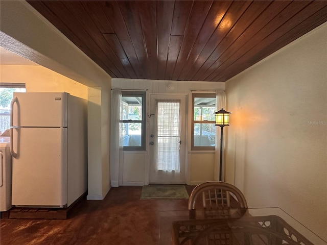 doorway to outside featuring dark colored carpet, lofted ceiling, washer / clothes dryer, and wooden ceiling