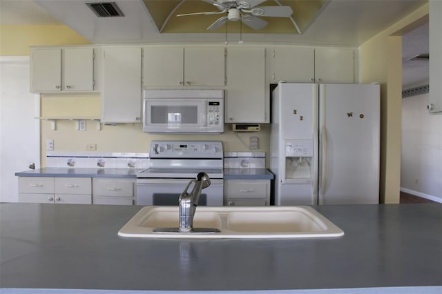 kitchen featuring white cabinets, ceiling fan, and white appliances