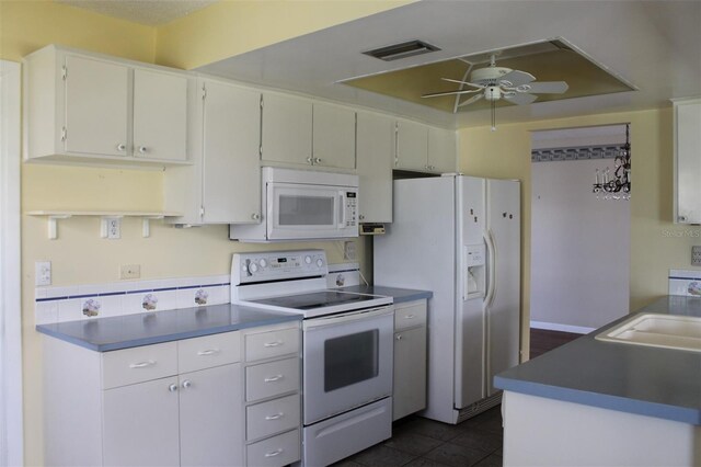 kitchen featuring ceiling fan, white appliances, dark tile flooring, sink, and white cabinets