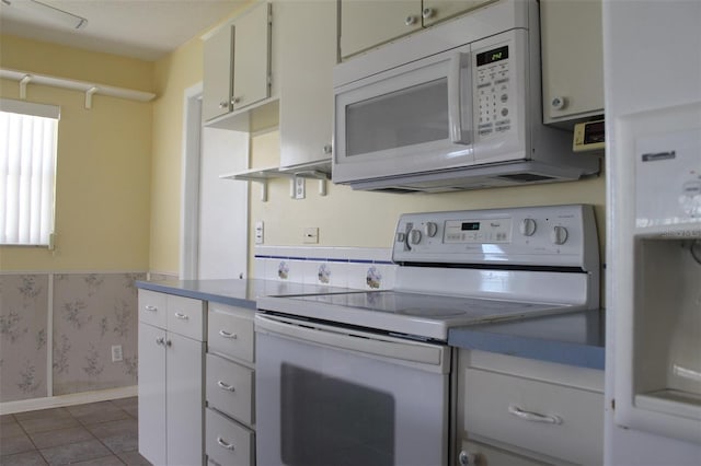 kitchen featuring white cabinetry, dark tile flooring, and electric stove