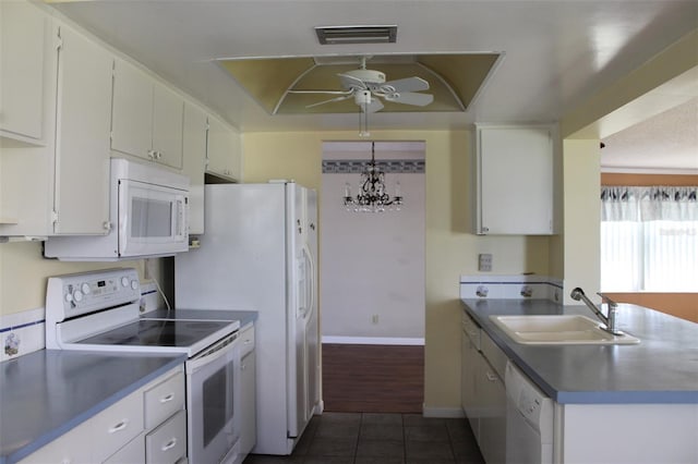 kitchen with ceiling fan with notable chandelier, dark tile flooring, white cabinets, sink, and white appliances