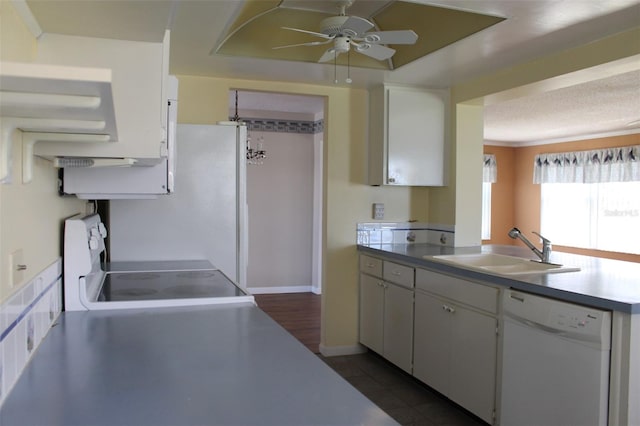 kitchen featuring white cabinetry, stove, sink, dark tile flooring, and dishwasher