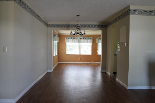 interior space with dark hardwood / wood-style floors, a textured ceiling, and a chandelier