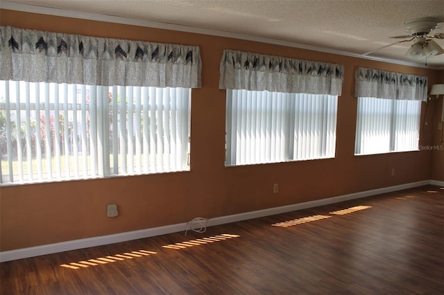 unfurnished room featuring a healthy amount of sunlight, a textured ceiling, ceiling fan, and dark hardwood / wood-style floors