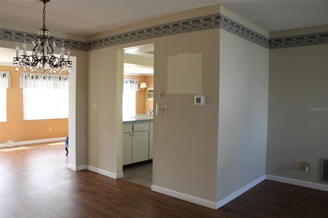 unfurnished dining area with a notable chandelier, sink, and tile floors