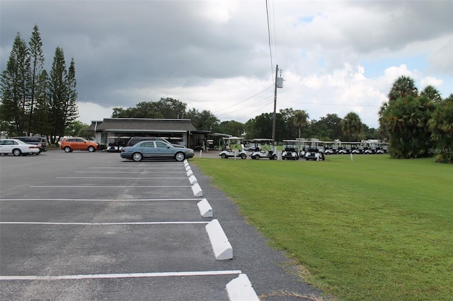 view of parking / parking lot featuring a lawn