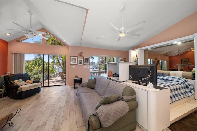 living room with light hardwood / wood-style floors and high vaulted ceiling