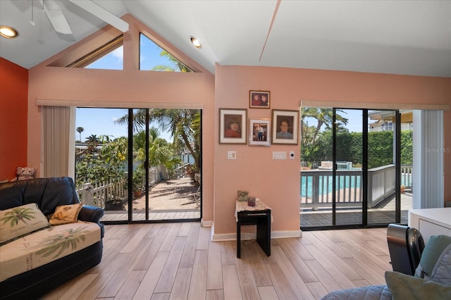 living room featuring ceiling fan, lofted ceiling, and light hardwood / wood-style flooring