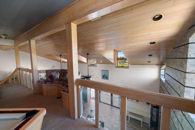 hallway featuring carpet floors, wooden ceiling, and vaulted ceiling