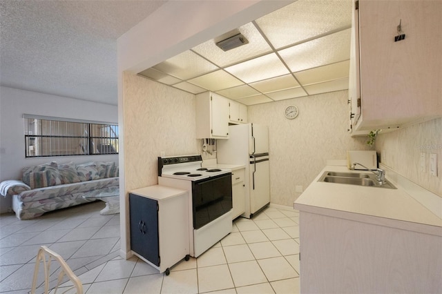 kitchen with white cabinetry, sink, light tile patterned floors, and white appliances