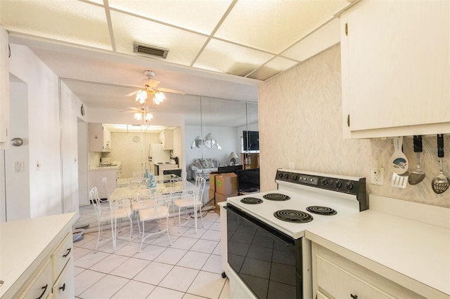 kitchen with electric range, ceiling fan, a drop ceiling, and light tile patterned floors