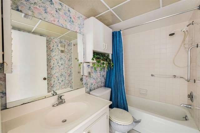 full bathroom featuring vanity, a drop ceiling, toilet, and shower / tub combo