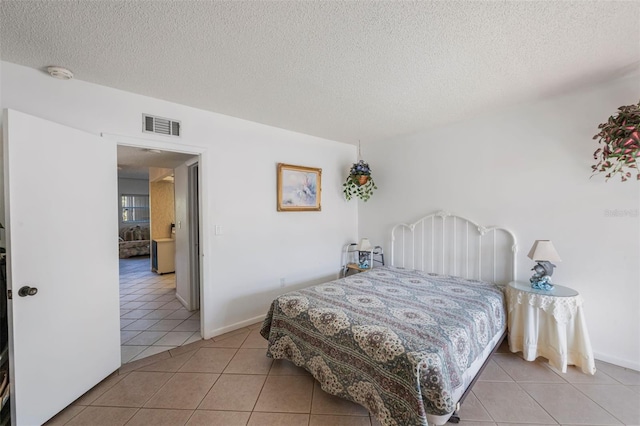 bedroom with light tile patterned flooring and a textured ceiling