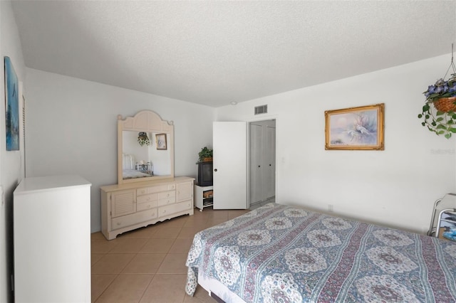 bedroom featuring light tile patterned floors and a textured ceiling