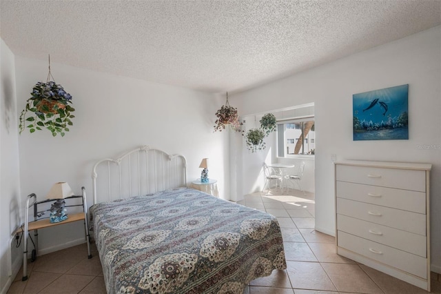 bedroom featuring light tile patterned floors and a textured ceiling